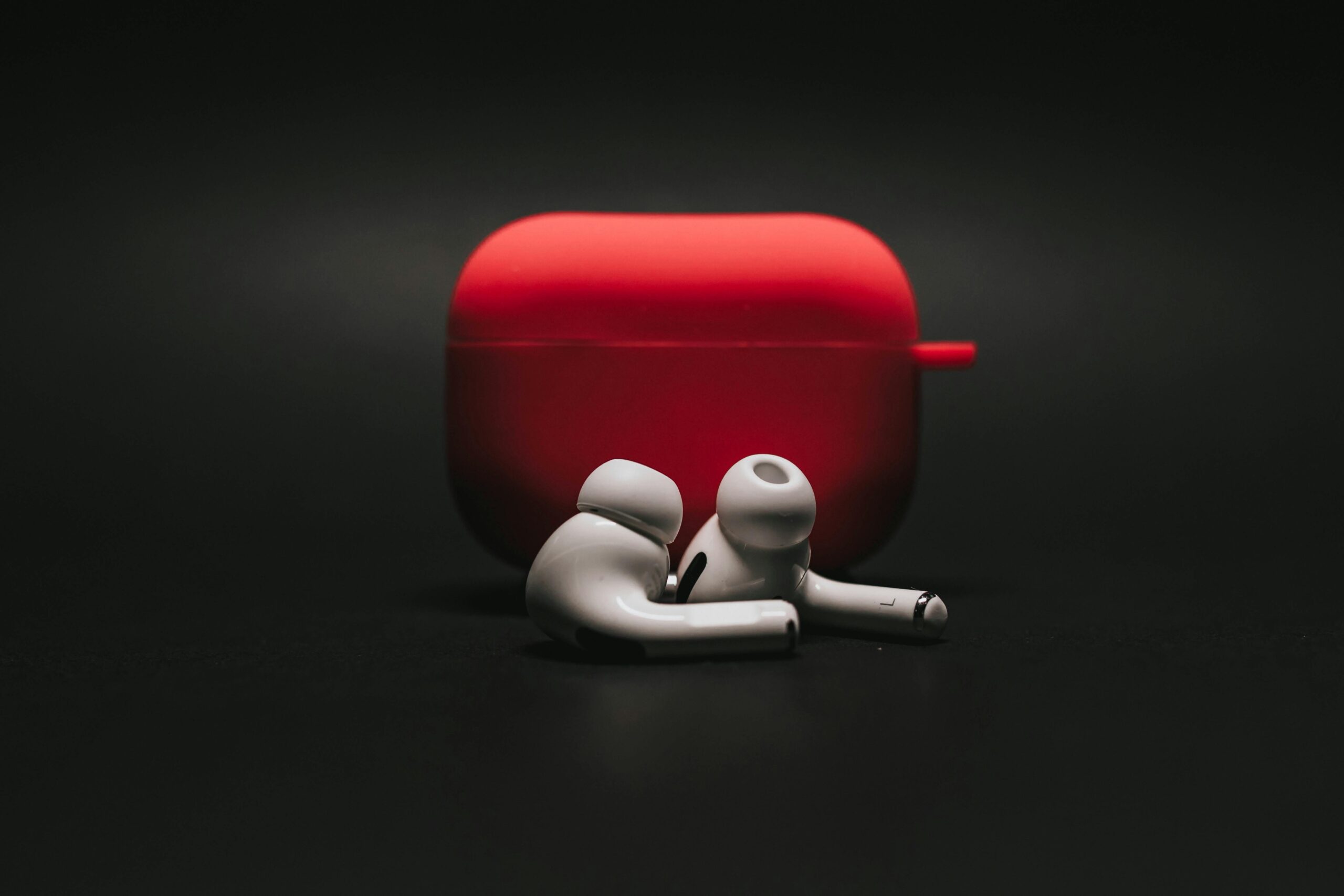 “Close-up of sleek wireless cordless earbuds nestled in an open charging case, with one earbud lifted to showcase ergonomic design—perfect for uninterrupted audiobook listening.”